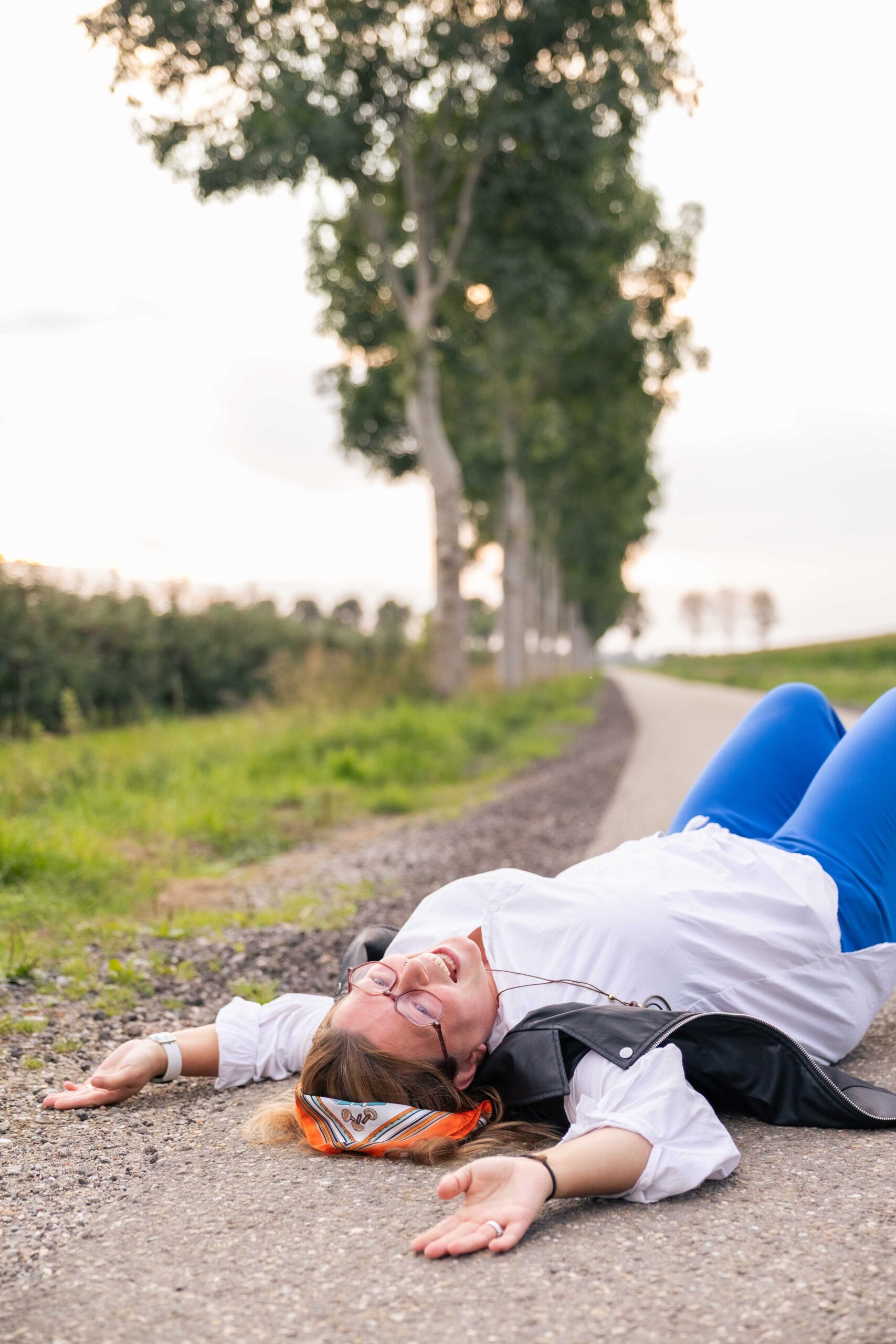 Isabel Bekhuis lachend liggend op een landweg